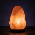 Himalayan pink salt lamp glowing warm orange on wooden base